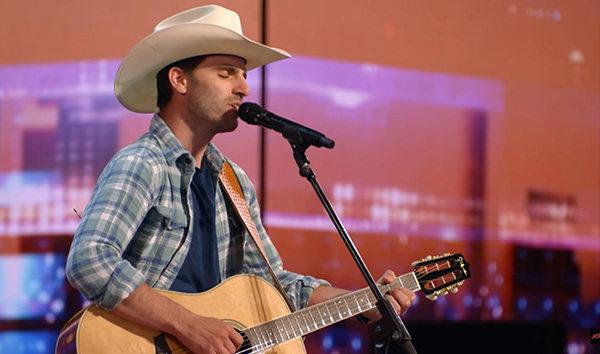 Mitch Rossell on stage at an outdoor venue